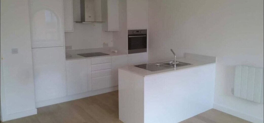 Finished kitchen installation with island unit and integrated appliances in a residential apartment.