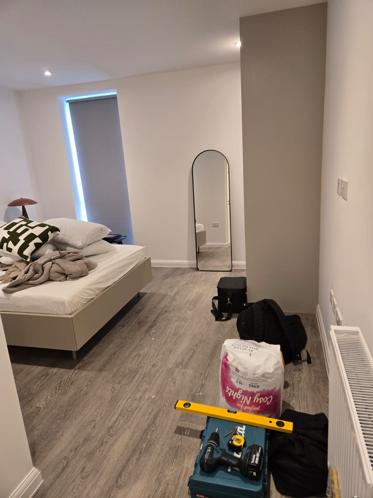 Bedroom installation in progress with spirit level, drill, and tools laid out on site.
