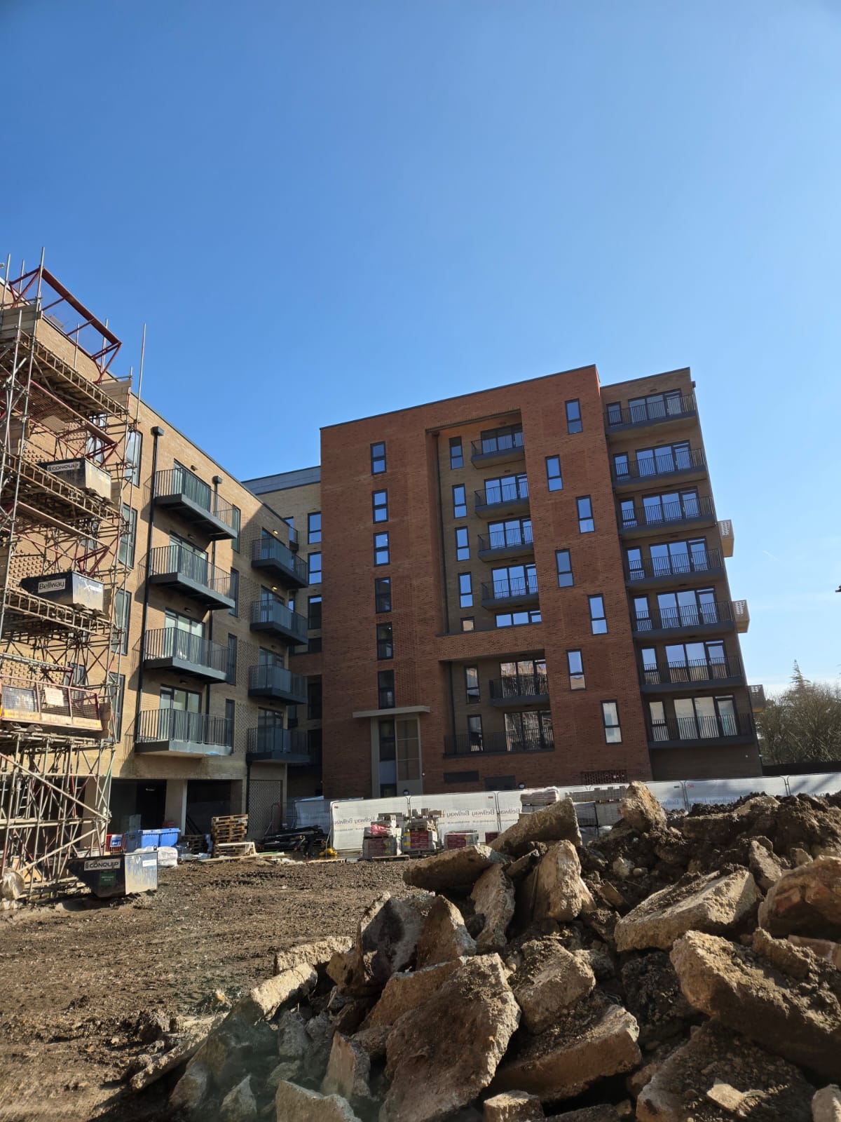 Multi-storey residential buildings in mixed stages of completion across a large development supported by Smart Corpo.